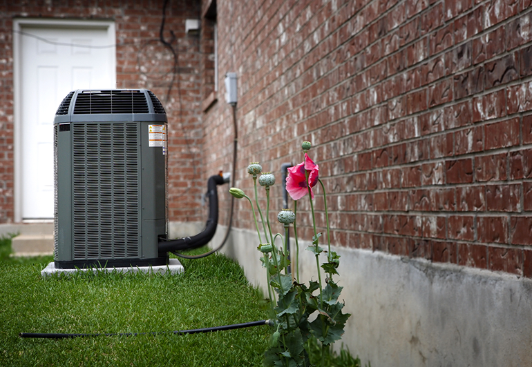 HVAC machine installed outside on a concrete pavements and green grass around it