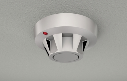 Ceiling-mounted smoke detector with circular design, vented casing, and red LED status indicator.