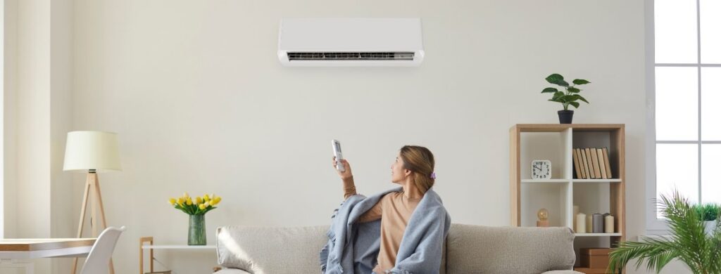 A woman changing the temperature for her HVAC unit.