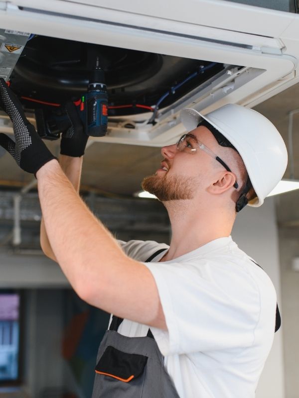 A man working on a commercial HVAC unit. 