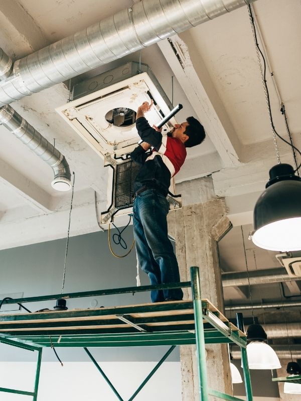 A man working on a commercial HVAC unit. 