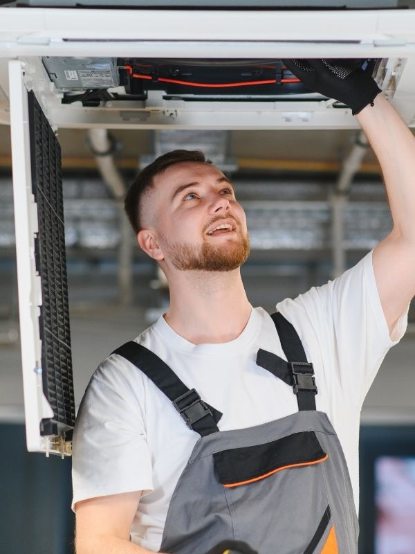 An HVAC Technician working on commercial HVAC ductwork. 