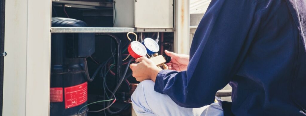 A man working on a commercial HVAC unit. 