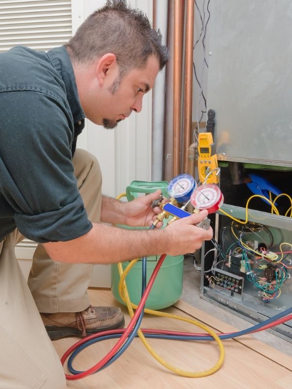 An HVAC Technician Inspecting an Air Conditioning Unit.