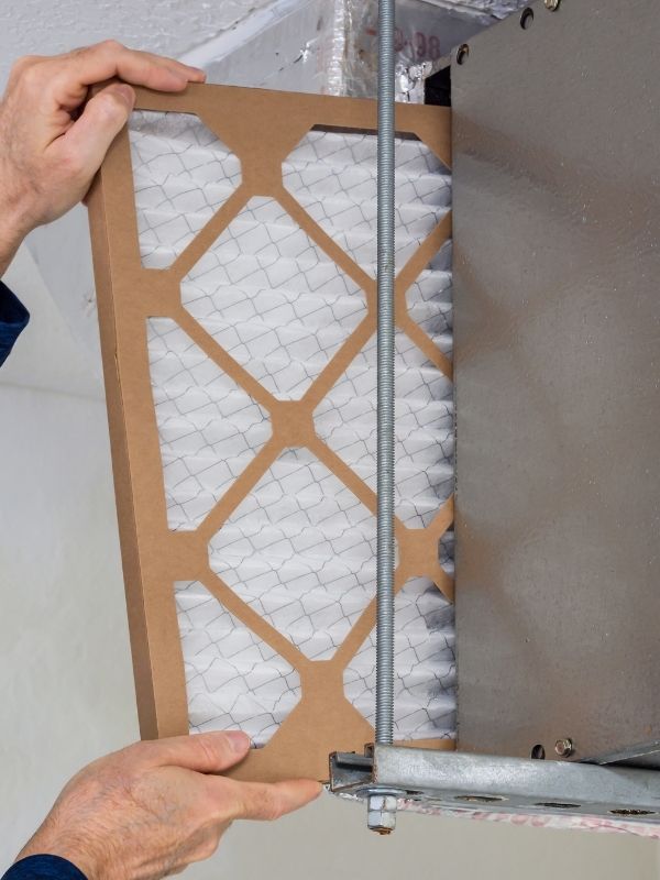 A technician replacing an air filter on an hvac unit.