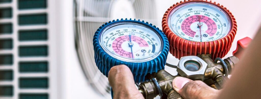 An HVAC technician is inspecting an air conditioning unit.